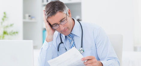 GP reading a form or certificate